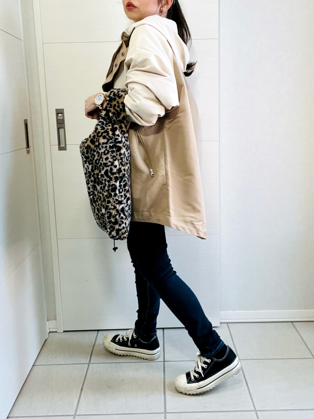 ベージュ系のマウンテンパーカー、ホワイト系のスウェット、ブルー系のデニムパンツを着用したレディースの秋コーディネートの5枚目の写真