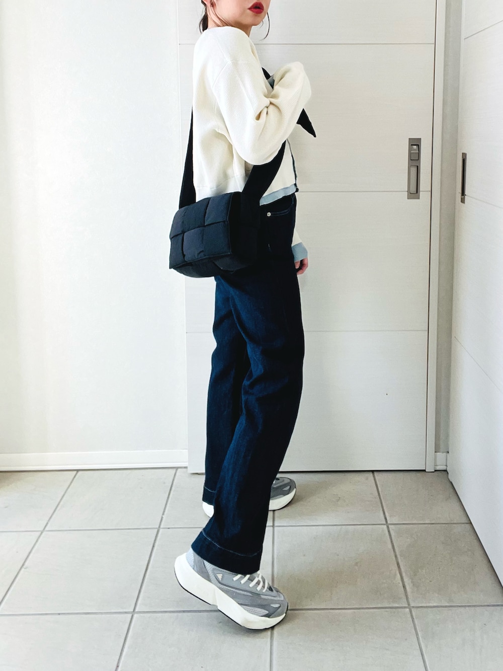 ホワイト系のカーディガン/ボレロ、グレー系のスニーカー、ブルー系のデニムパンツを着用したレディースの春コーディネートの5枚目の写真