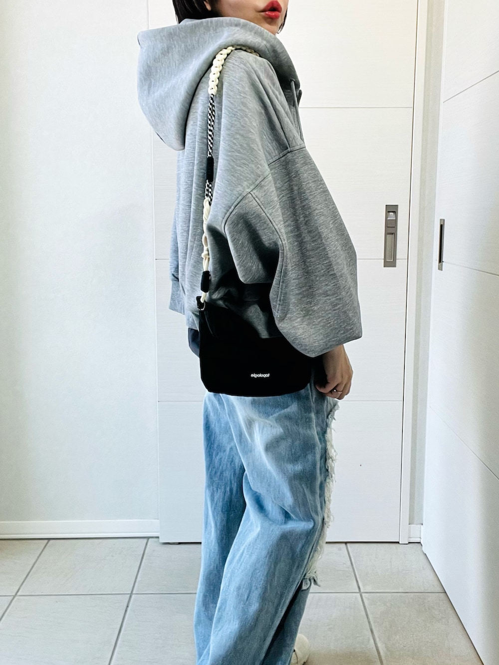 グレー系のパーカー、グレー系のTシャツ/カットソー、ブルー系のデニムパンツを着用したレディースの冬コーディネートの3枚目の写真