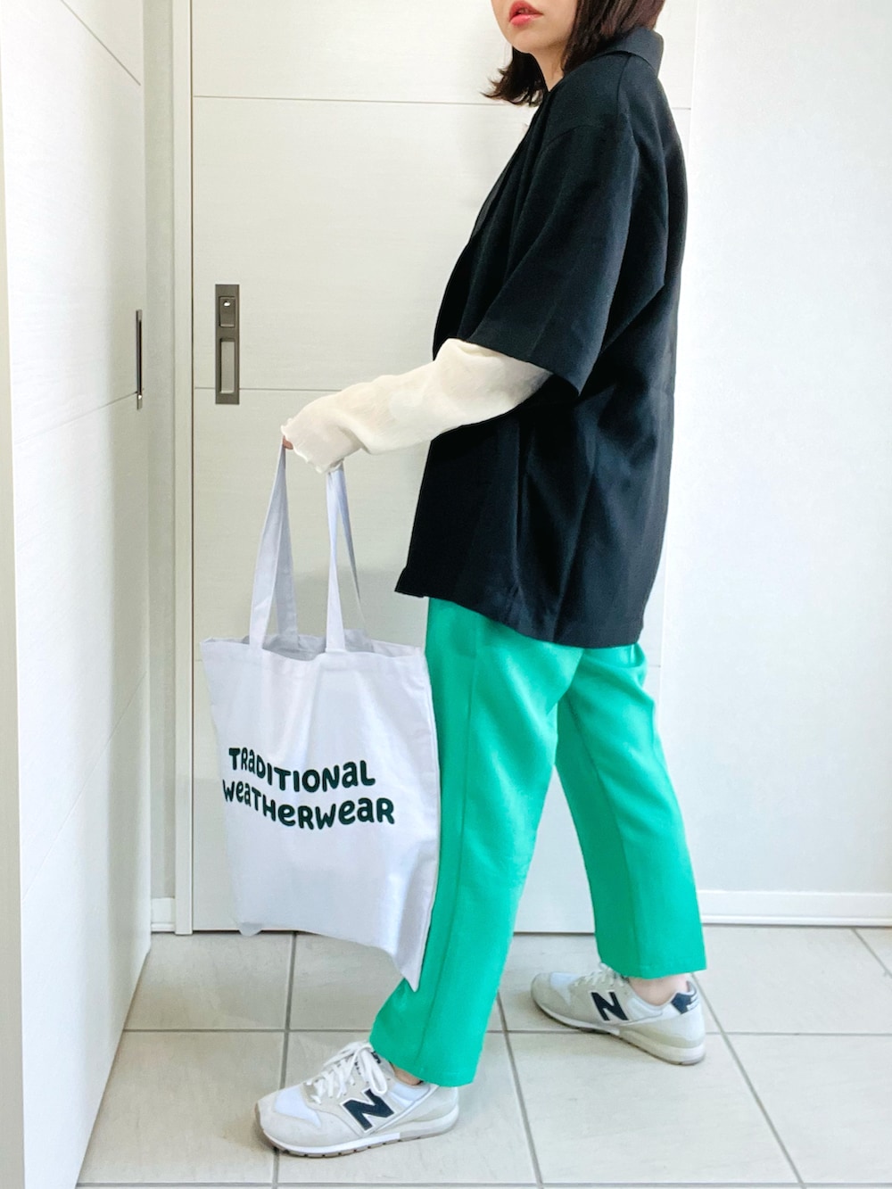 ブラック系のシャツ/ブラウス、グリーン系のスラックス、ホワイト系のスニーカーを着用したレディースの春コーディネートの3枚目の写真