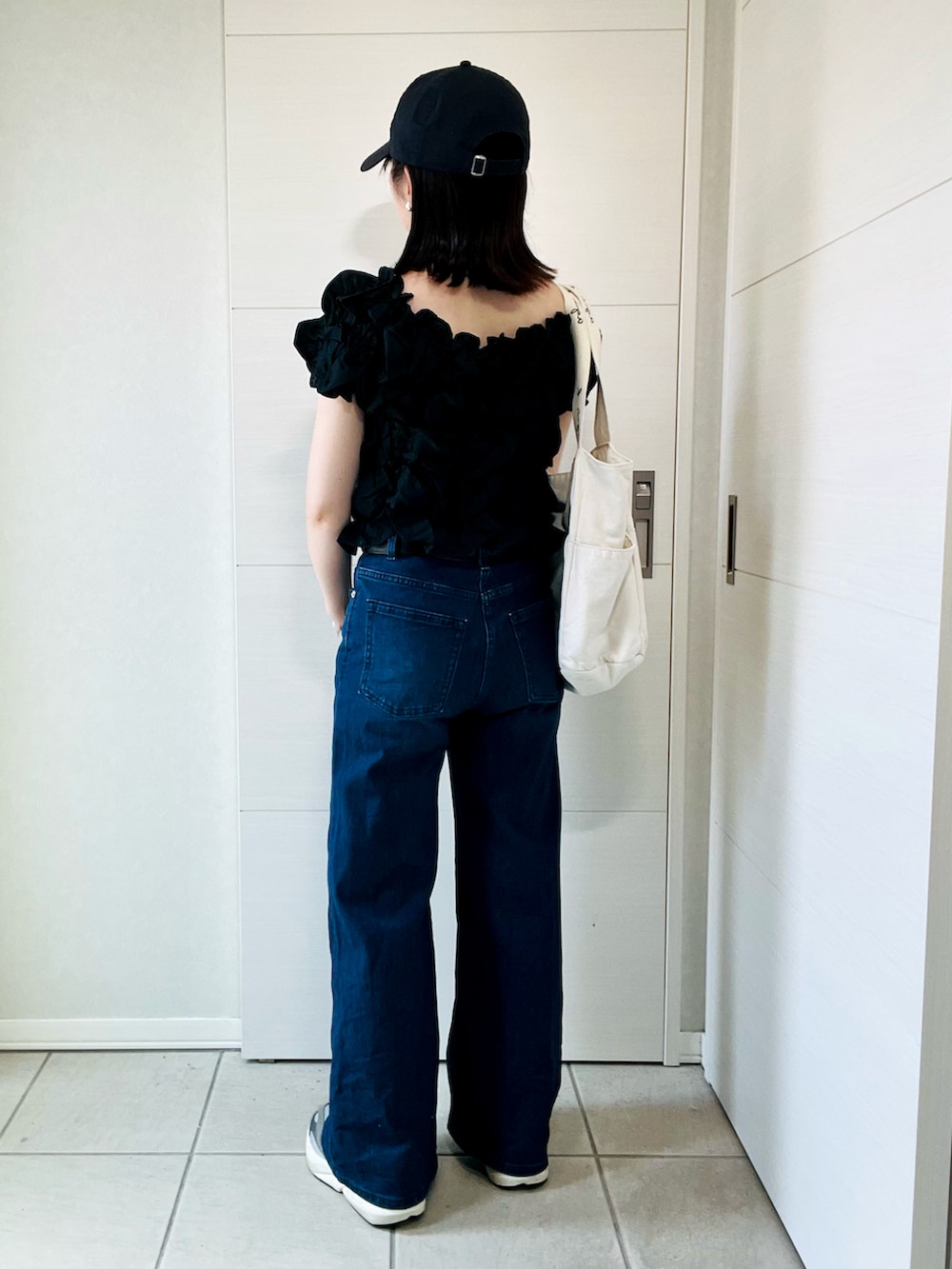 ブラック系のシャツ/ブラウス、ベージュ系のトートバッグ、グレー系のスニーカーを着用したレディースの夏コーディネートの5枚目の写真