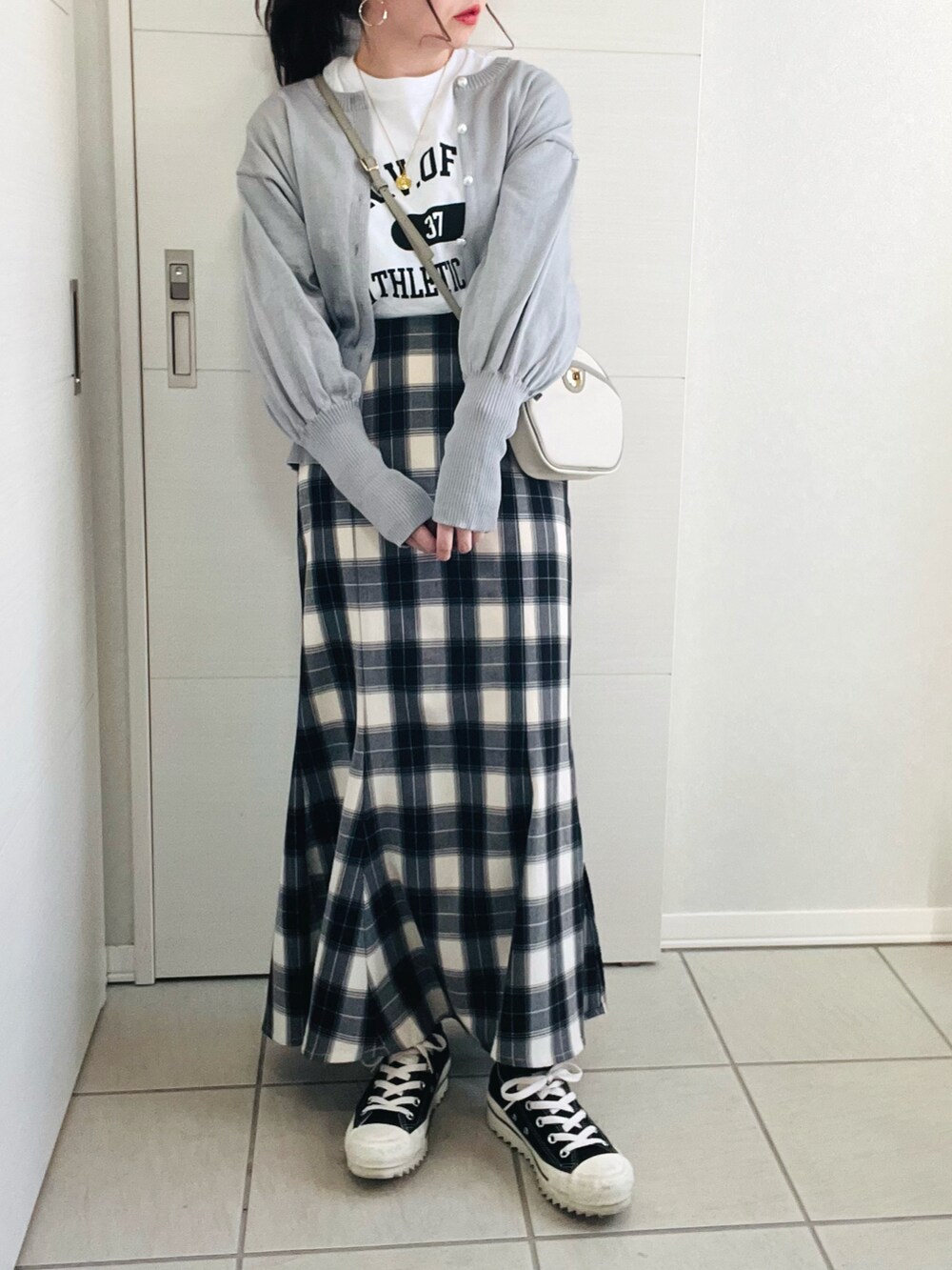 グレー系のカーディガン/ボレロ、ホワイト系のTシャツ/カットソー、ブラック系のスカートを着用したレディースの冬コーディネートの4枚目の写真