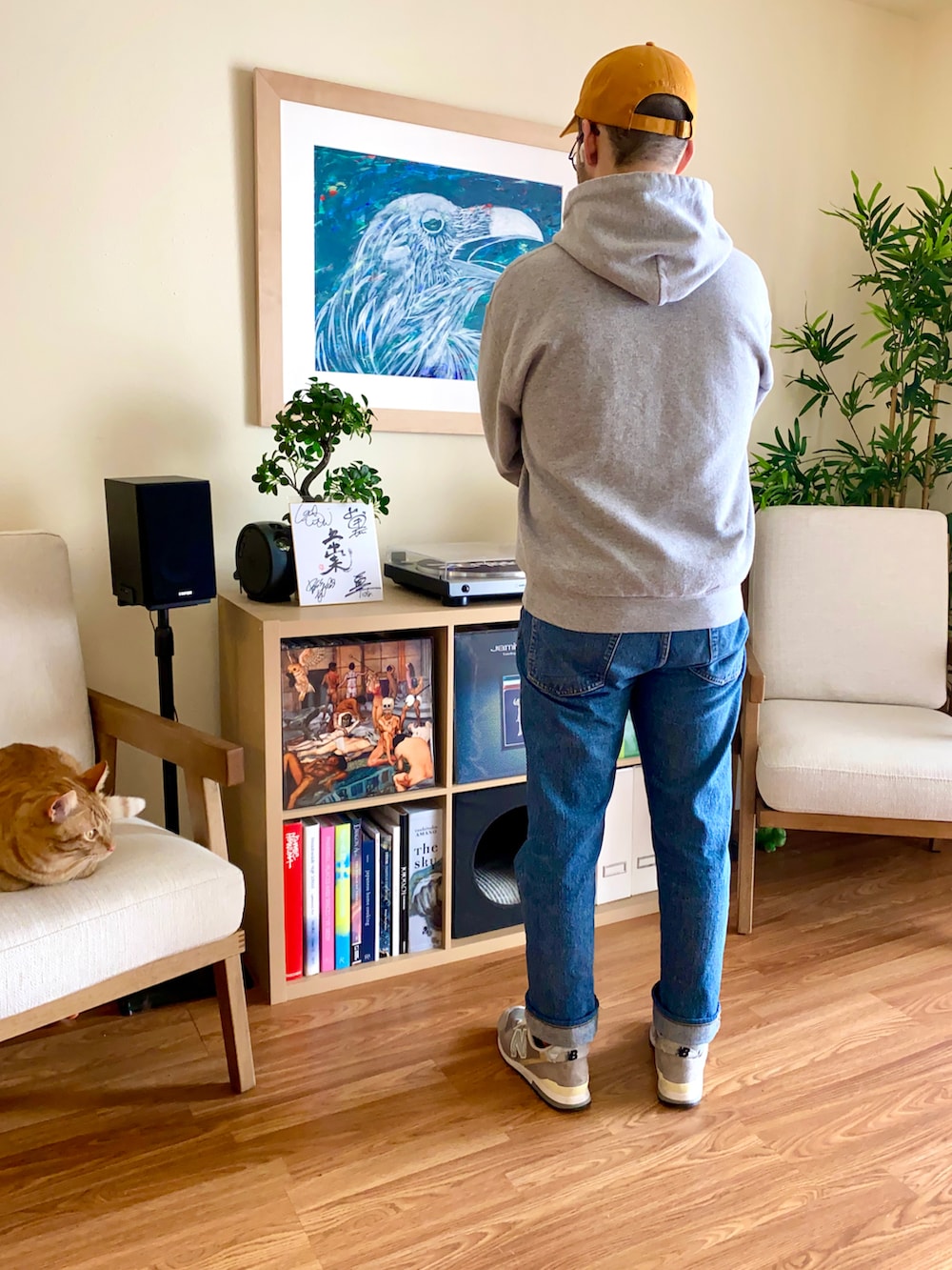 ブルー系のデニムパンツ、グレー系のパーカー、ブラック系のスニーカーを着用したメンズの春コーディネートの2枚目の写真