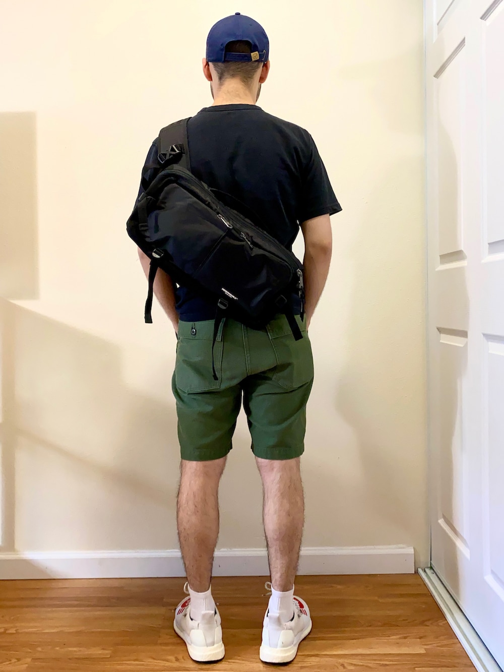 ブラック系のTシャツ/カットソー、グリーン系のその他パンツ、ホワイト系のシューズを着用したメンズの秋コーディネートの2枚目の写真