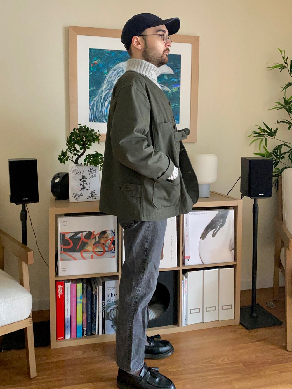 ブラック系のデニムパンツ、ブラック系のドレスシューズ、グリーン系のノーカラージャケットを着用したメンズの冬コーディネートの2枚目の写真