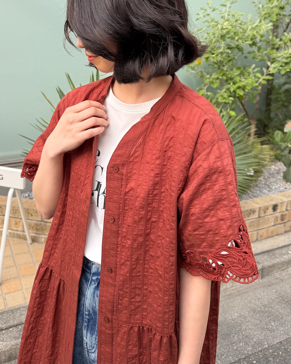 ブルー系のデニムパンツ、ホワイト系のTシャツ/カットソー、ブラウン系のシャツワンピースを着用したレディースの夏コーディネートの4枚目の写真
