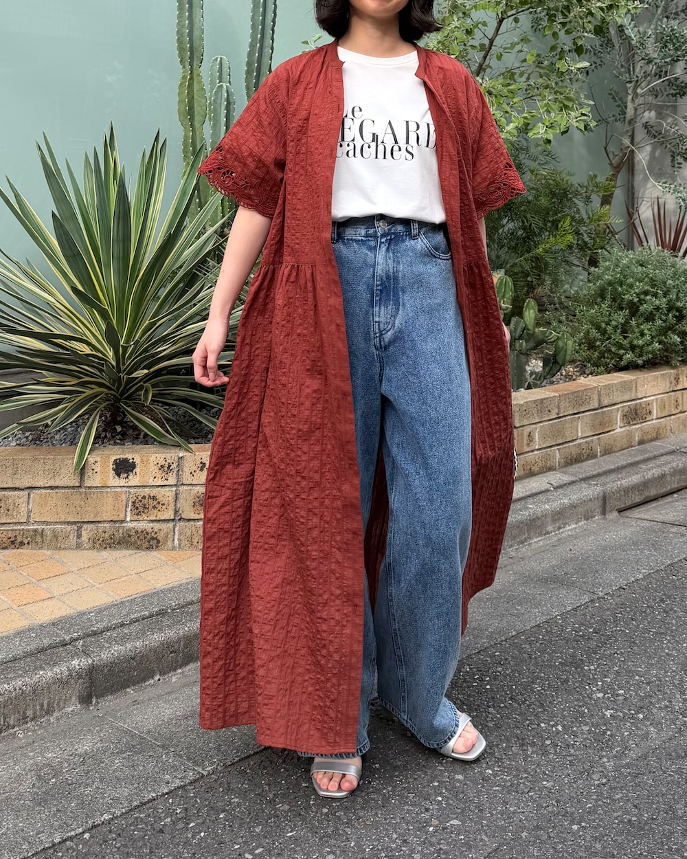 ブルー系のデニムパンツ、ホワイト系のTシャツ/カットソー、ブラウン系のシャツワンピースを着用したレディースの夏コーディネートの3枚目の写真
