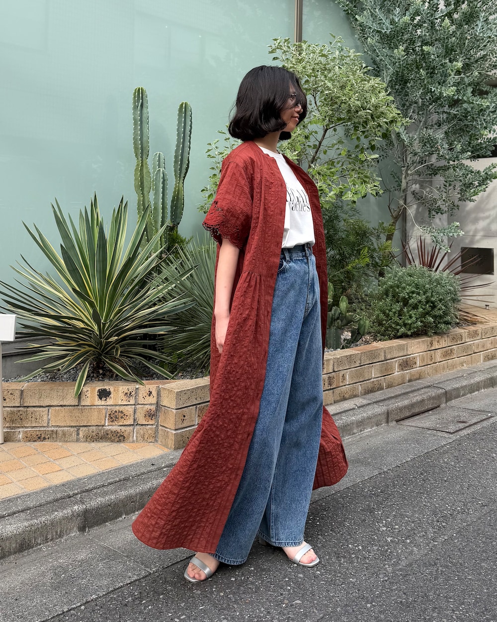 ブルー系のデニムパンツ、ホワイト系のTシャツ/カットソー、ブラウン系のシャツワンピースを着用したレディースの夏コーディネートの2枚目の写真
