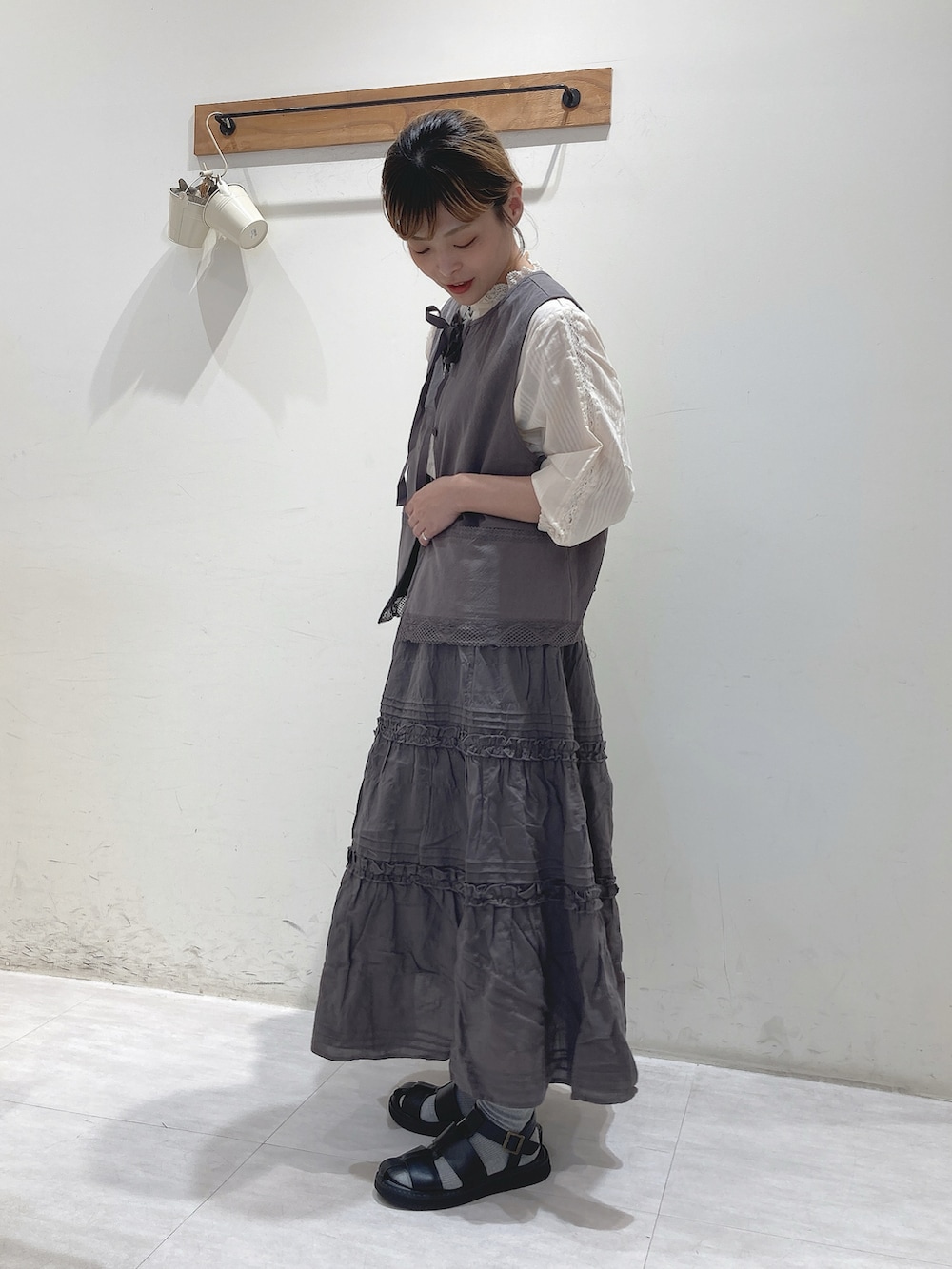 ホワイト系のシャツ/ブラウス、グレー系のベスト、グレー系のスカートを着用したレディースの夏コーディネートの2枚目の写真