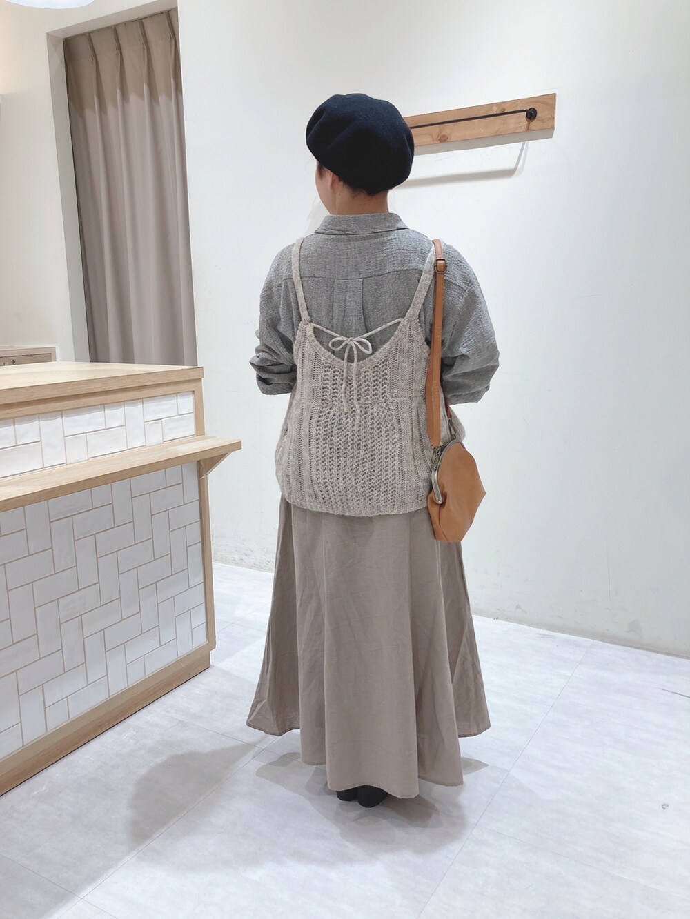 グレー系のシャツ/ブラウス、イエロー系のハンドバッグ、ベージュ系のスカートを着用したレディースの秋コーディネートの3枚目の写真