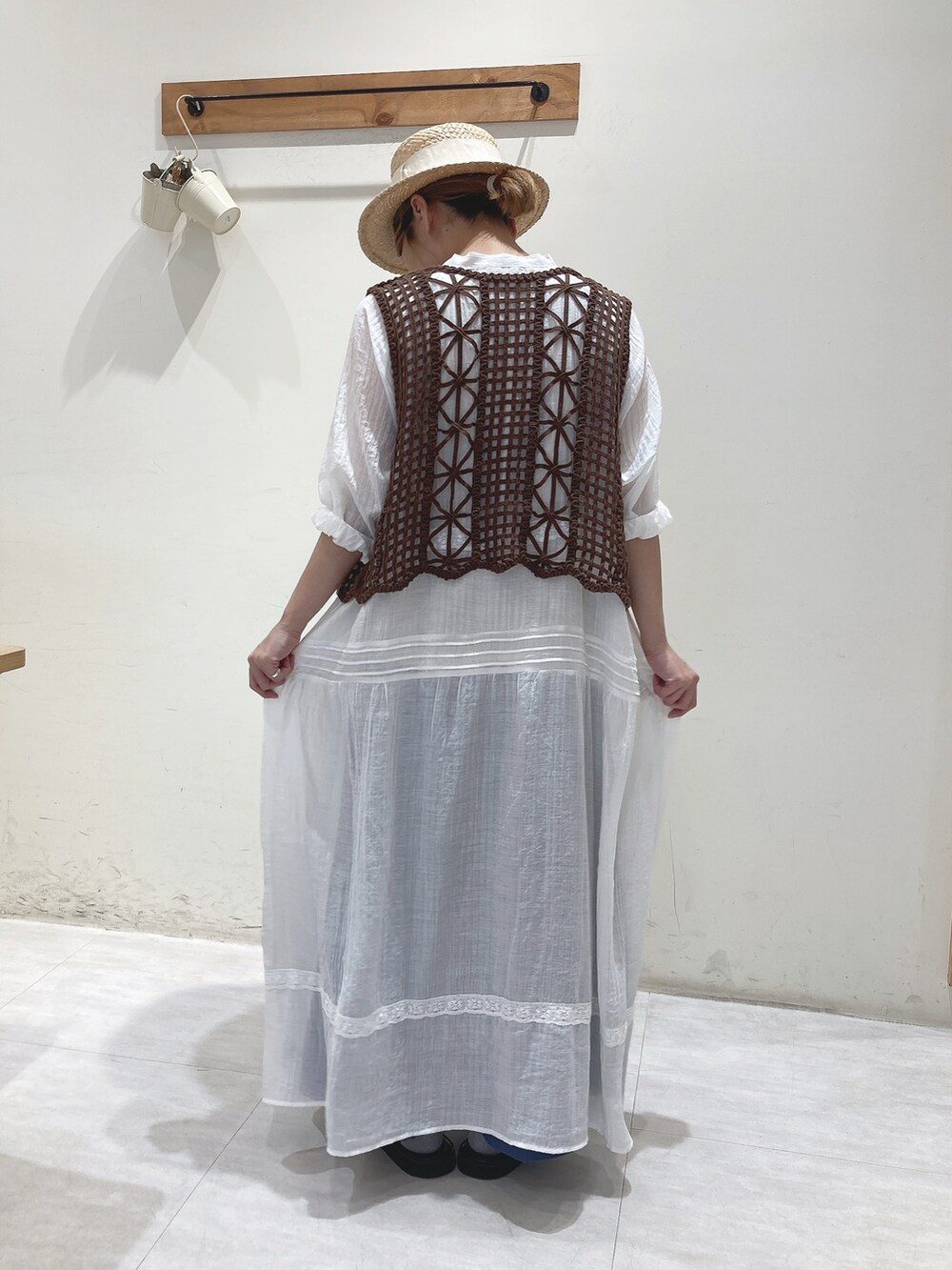 ブラウン系のベスト、ホワイト系のワンピース、ブルー系のその他パンツを着用したレディースの夏コーディネートの3枚目の写真