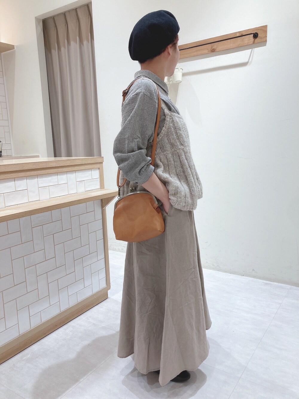 グレー系のシャツ/ブラウス、イエロー系のハンドバッグ、ベージュ系のスカートを着用したレディースの秋コーディネートの2枚目の写真