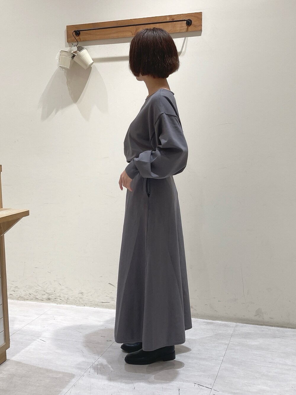 グレー系のニット/セーター、グレー系のスカート、ブラック系のノーカラージャケットを着用したレディースの秋コーディネートの5枚目の写真