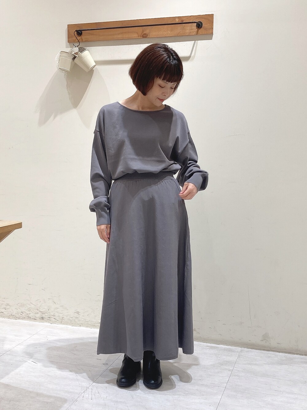 グレー系のニット/セーター、グレー系のスカート、ブラック系のノーカラージャケットを着用したレディースの秋コーディネートの4枚目の写真