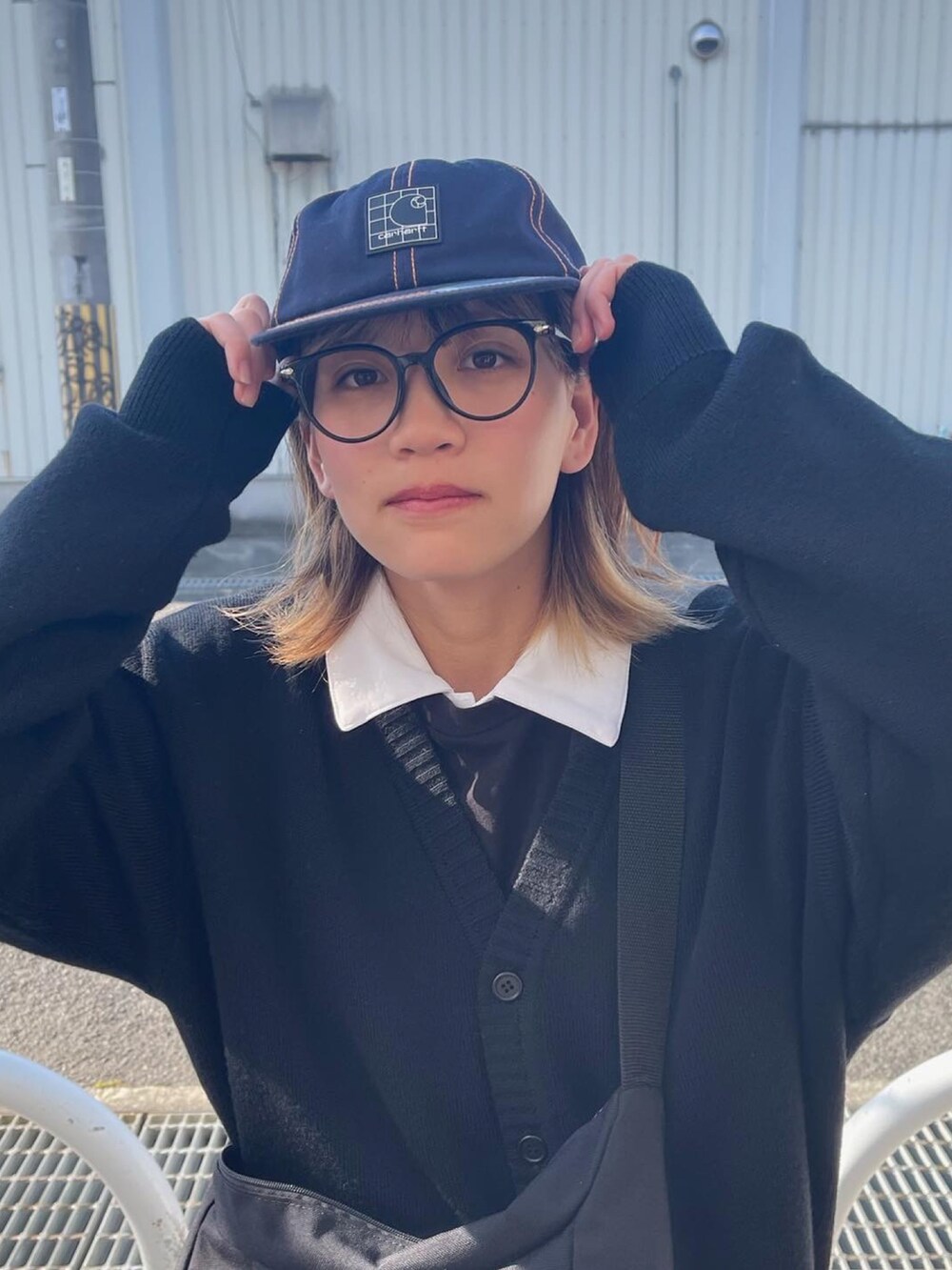 ブルー系のパンツ、ブラック系のスニーカー、ブラック系のカーディガン/ボレロを着用したレディースの冬コーディネートの2枚目の写真