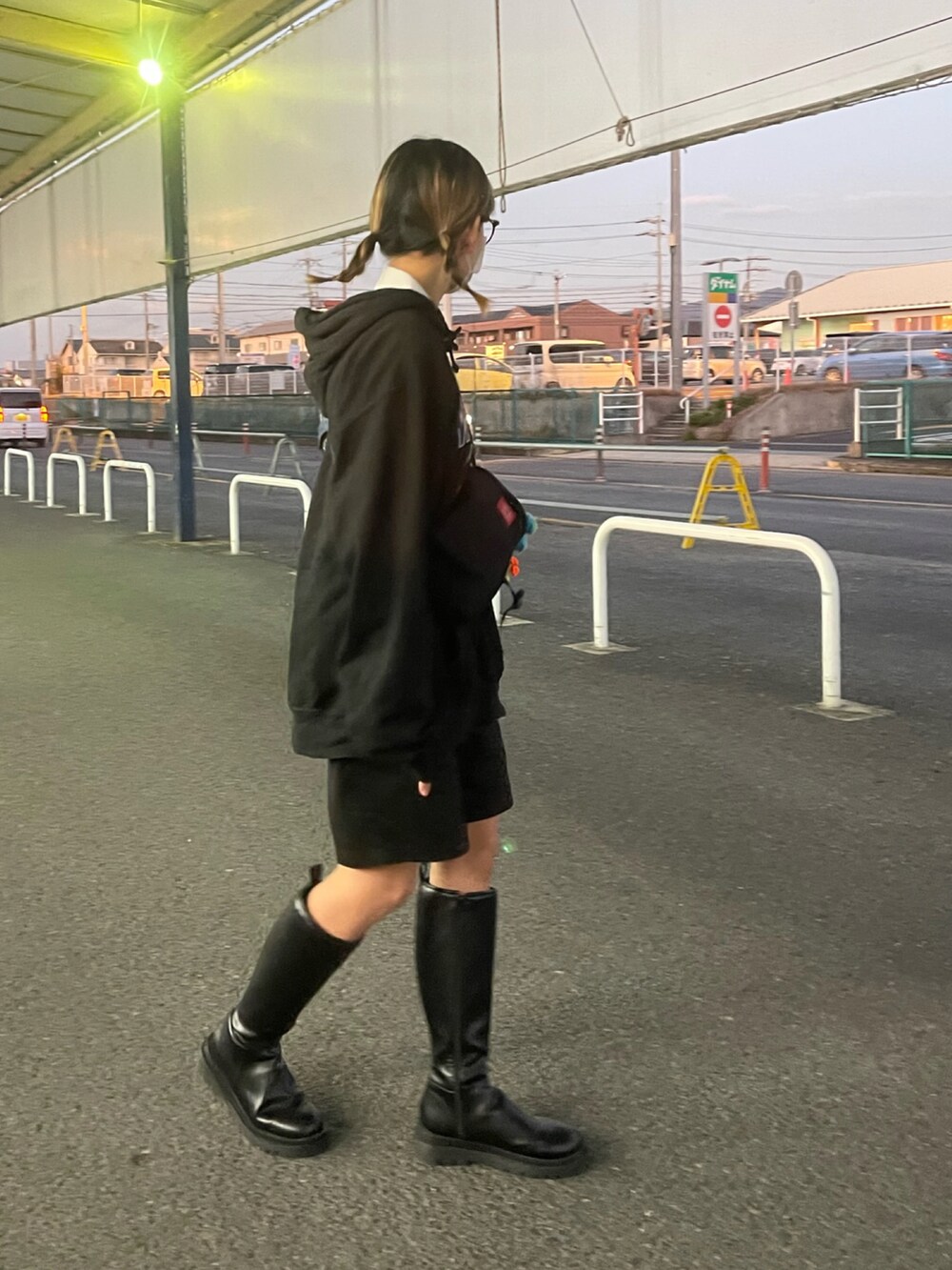 ブラック系のブーツ、ブラック系のショルダーバッグ、ブラック系のパンツを着用したレディースの冬コーディネートの2枚目の写真