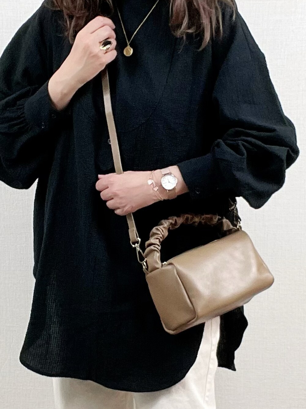 ブラック系のシャツ/ブラウス、ホワイト系のデニムパンツ、ブラウン系のハンドバッグを着用したレディースの春コーディネートの2枚目の写真