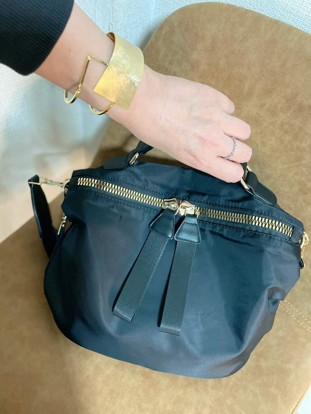 ブルー系のデニムパンツ、ブラック系のショルダーバッグ、シルバー系のパンプスを着用したレディースの冬コーディネートの3枚目の写真
