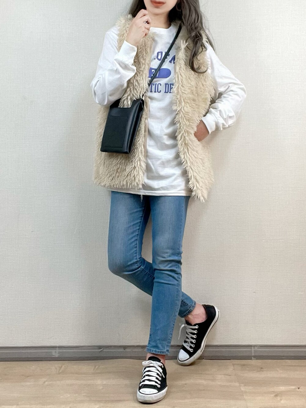 ホワイト系のベスト、ホワイト系のTシャツ/カットソー、ブラック系のショルダーバッグを着用したレディースの夏コーディネートの2枚目の写真