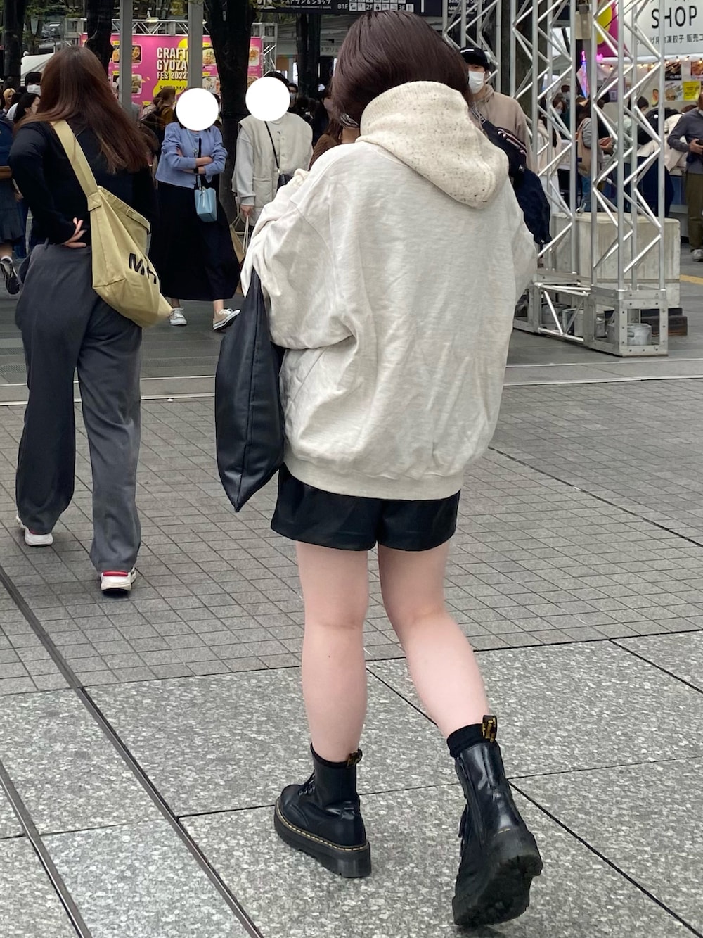 グレー系のスウェット、ブラック系のパンツ、ブラック系のブーツを着用したレディースの秋コーディネートの2枚目の写真