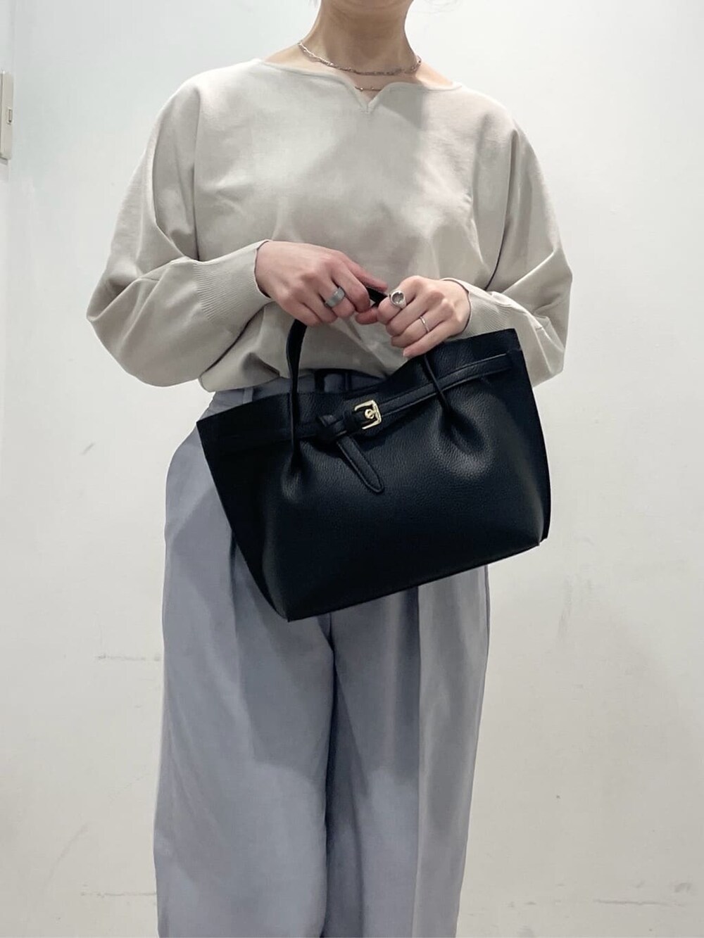 ブラック系のパンプス、グレー系のその他パンツ、ブラック系のトートバッグを着用したレディースの春コーディネートの6枚目の写真