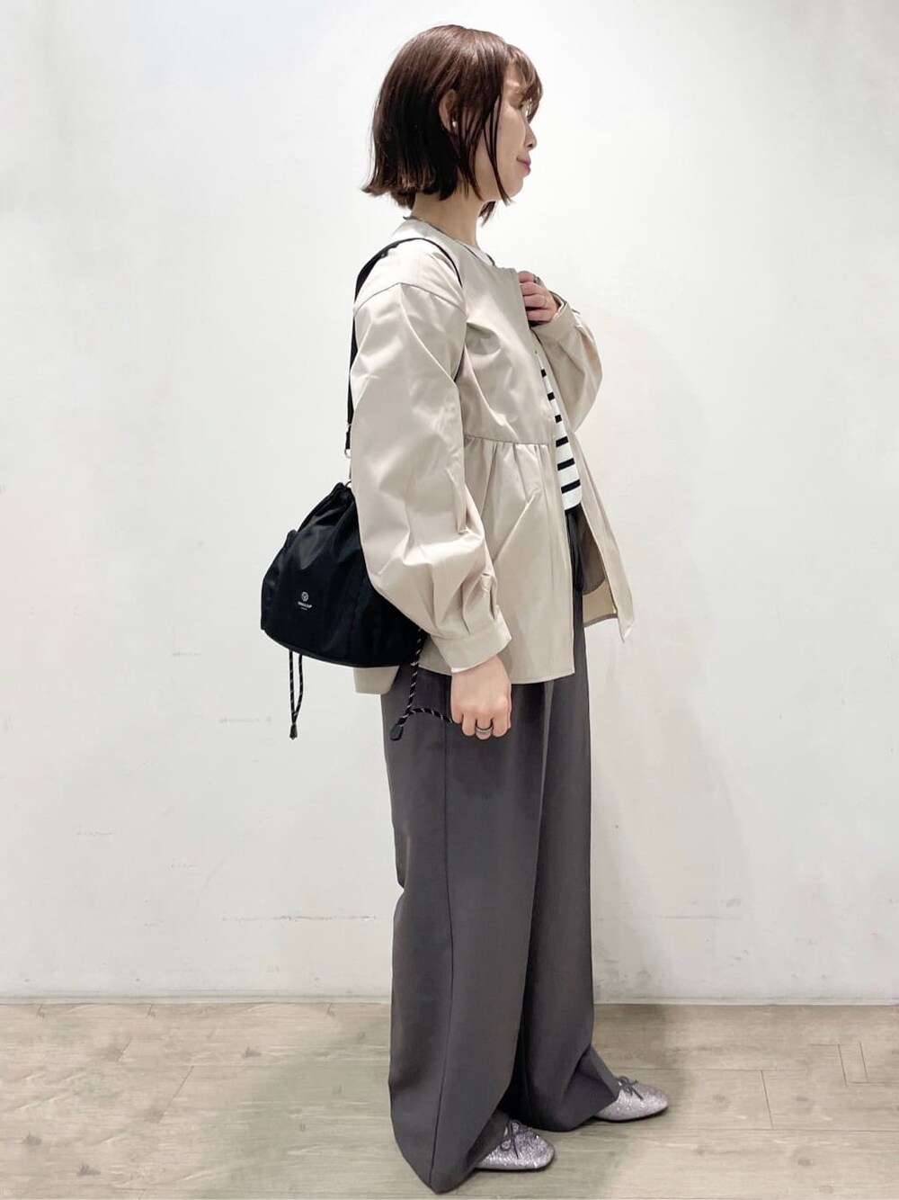 シルバー系のパンプス、ベージュ系のブルゾン、グレー系のその他パンツを着用したレディースの春コーディネートの2枚目の写真