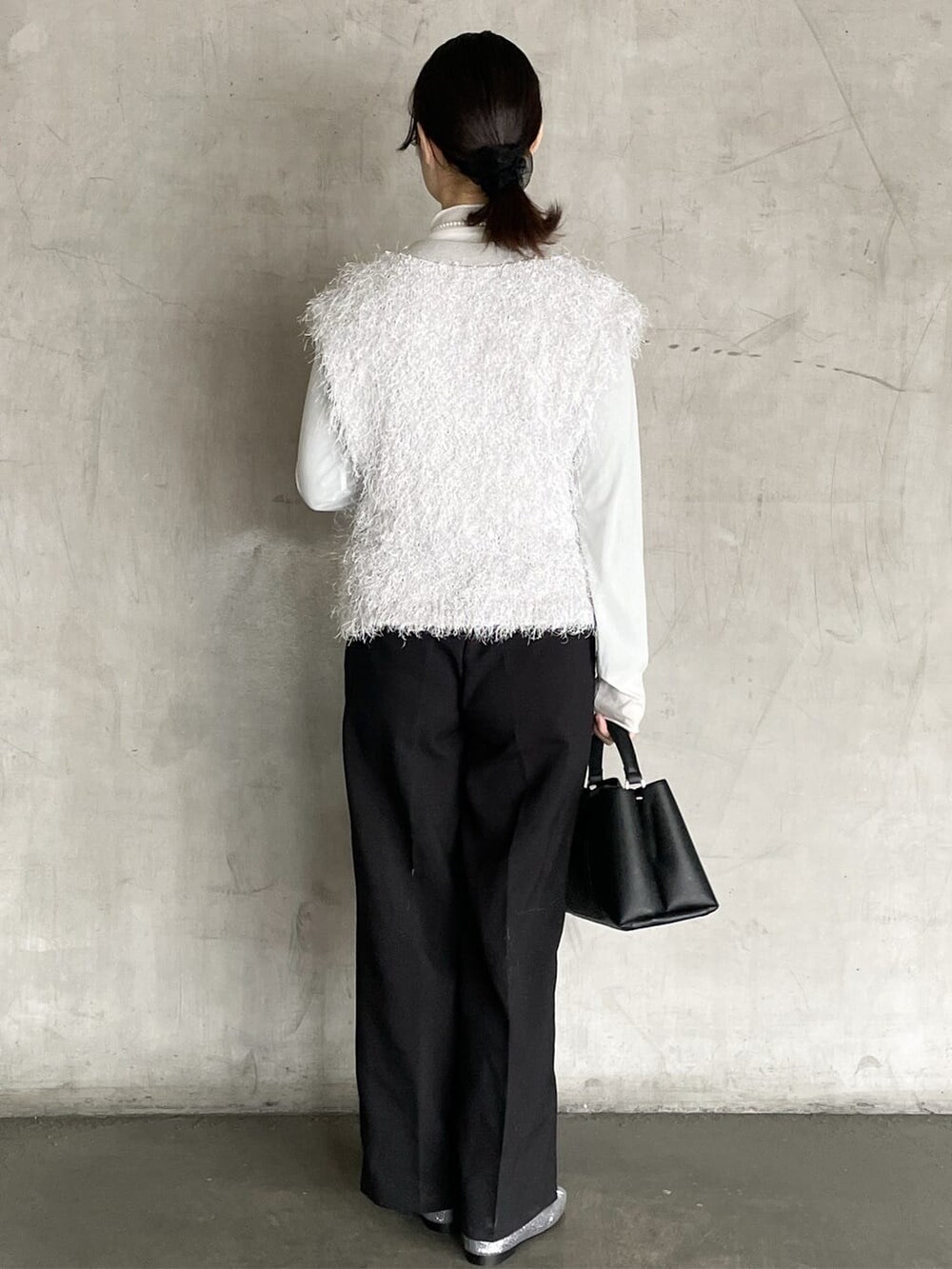 グレー系のニット/セーター、ブラック系のその他パンツ、ブラック系のハンドバッグを着用したレディースの冬コーディネートの4枚目の写真