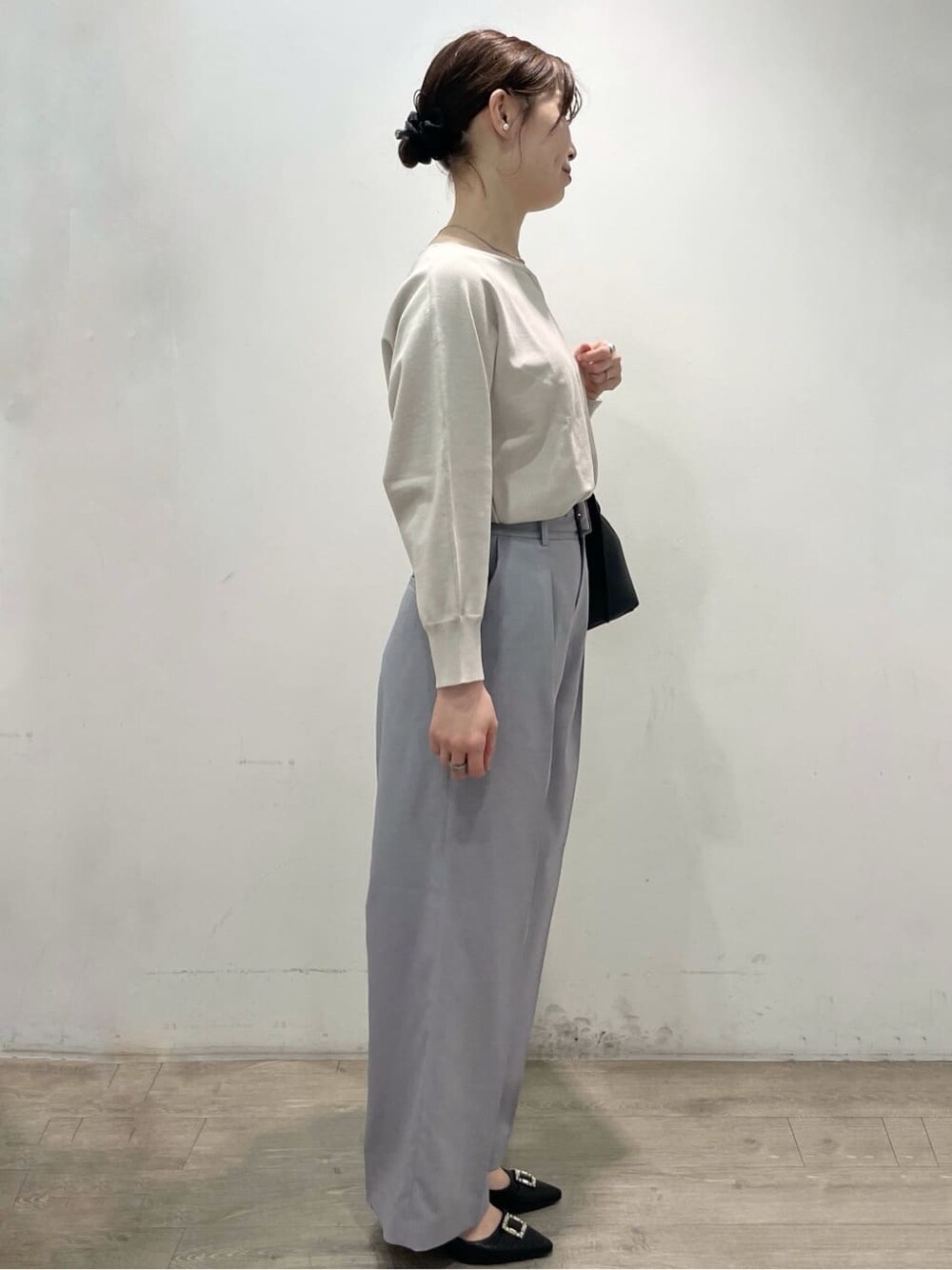ベージュ系のニット/セーター、グレー系のその他パンツ、ブラック系のトートバッグを着用したレディースの春コーディネートの3枚目の写真