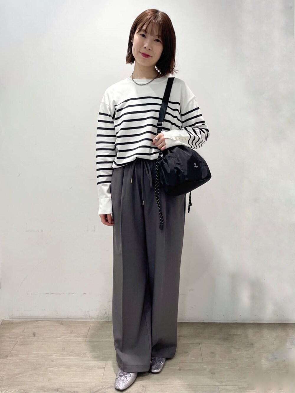 シルバー系のパンプス、ベージュ系のブルゾン、グレー系のその他パンツを着用したレディースの春コーディネートの4枚目の写真