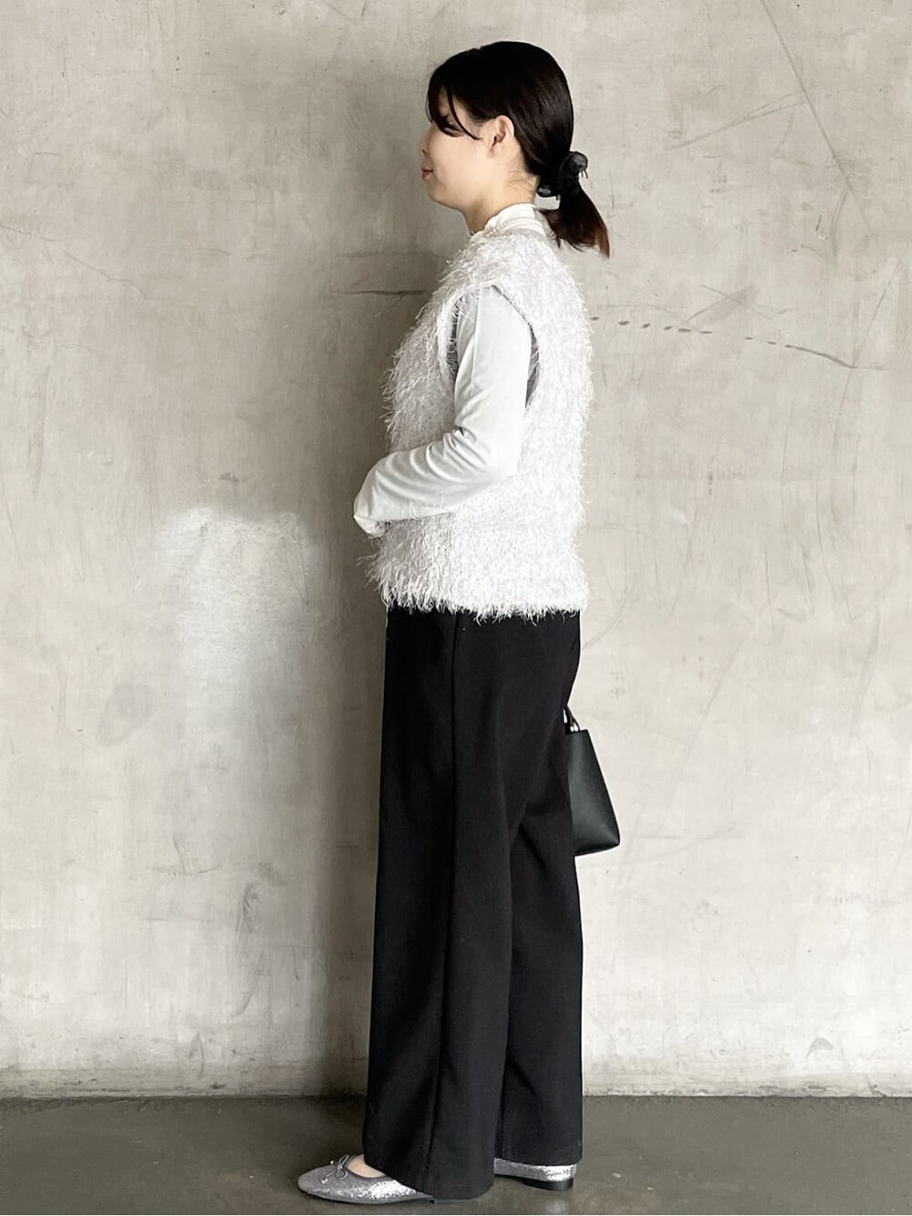 グレー系のニット/セーター、ブラック系のその他パンツ、ブラック系のハンドバッグを着用したレディースの冬コーディネートの5枚目の写真