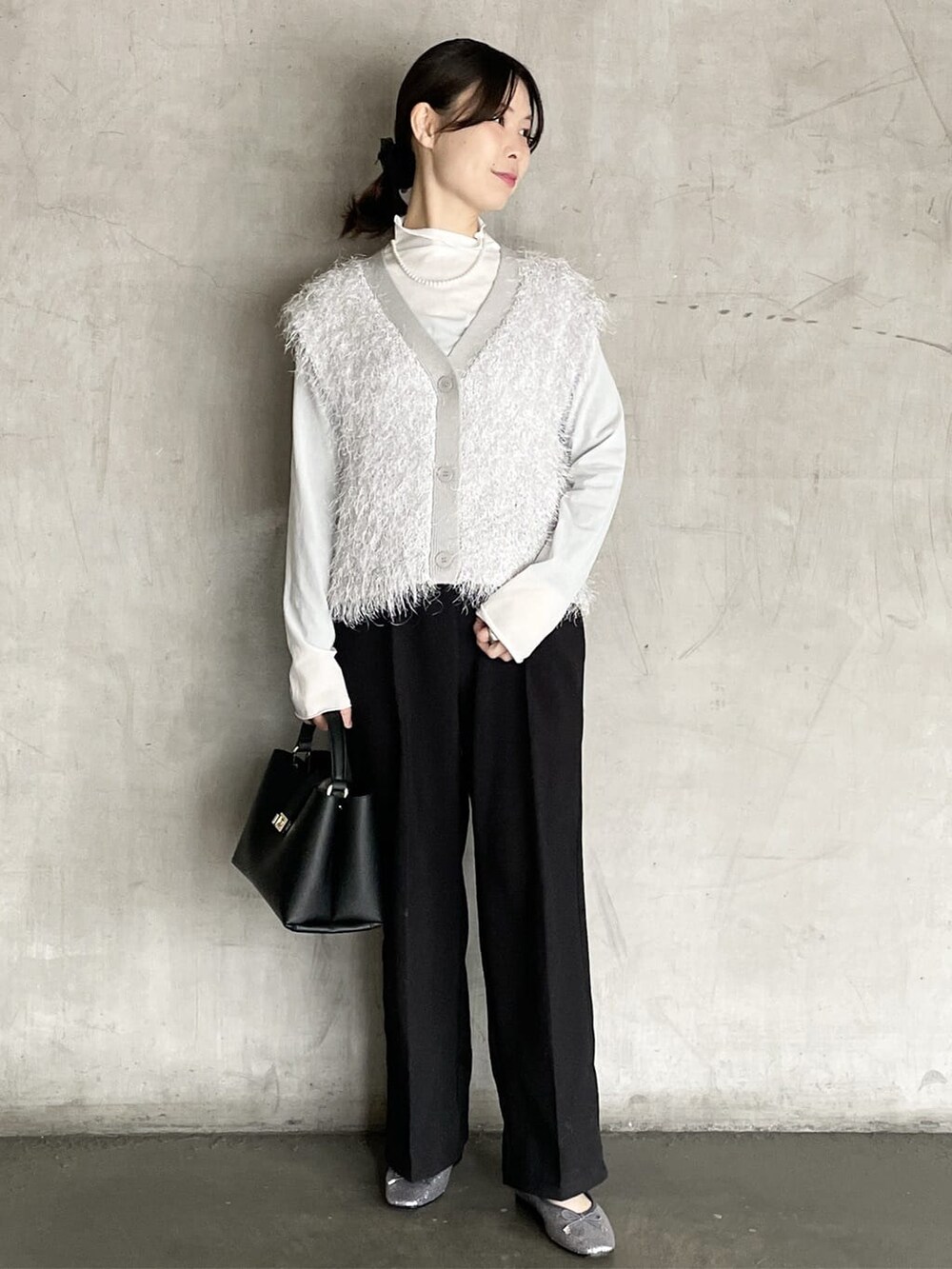 グレー系のニット/セーター、ブラック系のその他パンツ、ブラック系のハンドバッグを着用したレディースの冬コーディネートの2枚目の写真