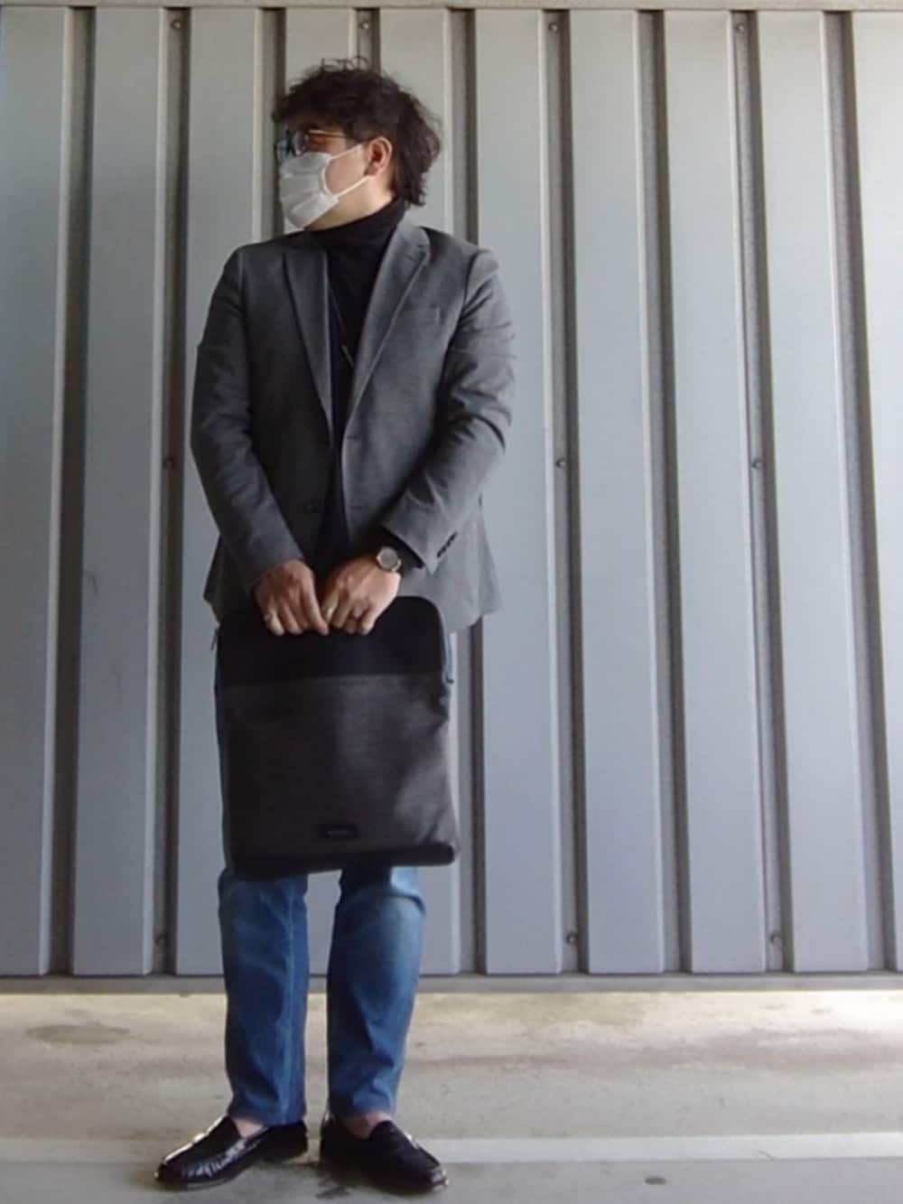 パープル系のローファー、ブルー系のデニムパンツ、その他のクラッチバッグを着用したメンズの春コーディネートの3枚目の写真