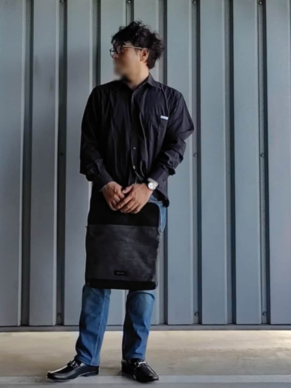 ブラック系のローファー、ブルー系のデニムパンツ、その他のクラッチバッグを着用したメンズの秋コーディネートの2枚目の写真