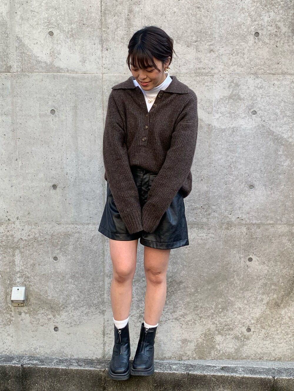 ブラック系のその他アウター、ブラウン系のトップス、ブラック系のブーツを着用したレディースの冬コーディネートの2枚目の写真