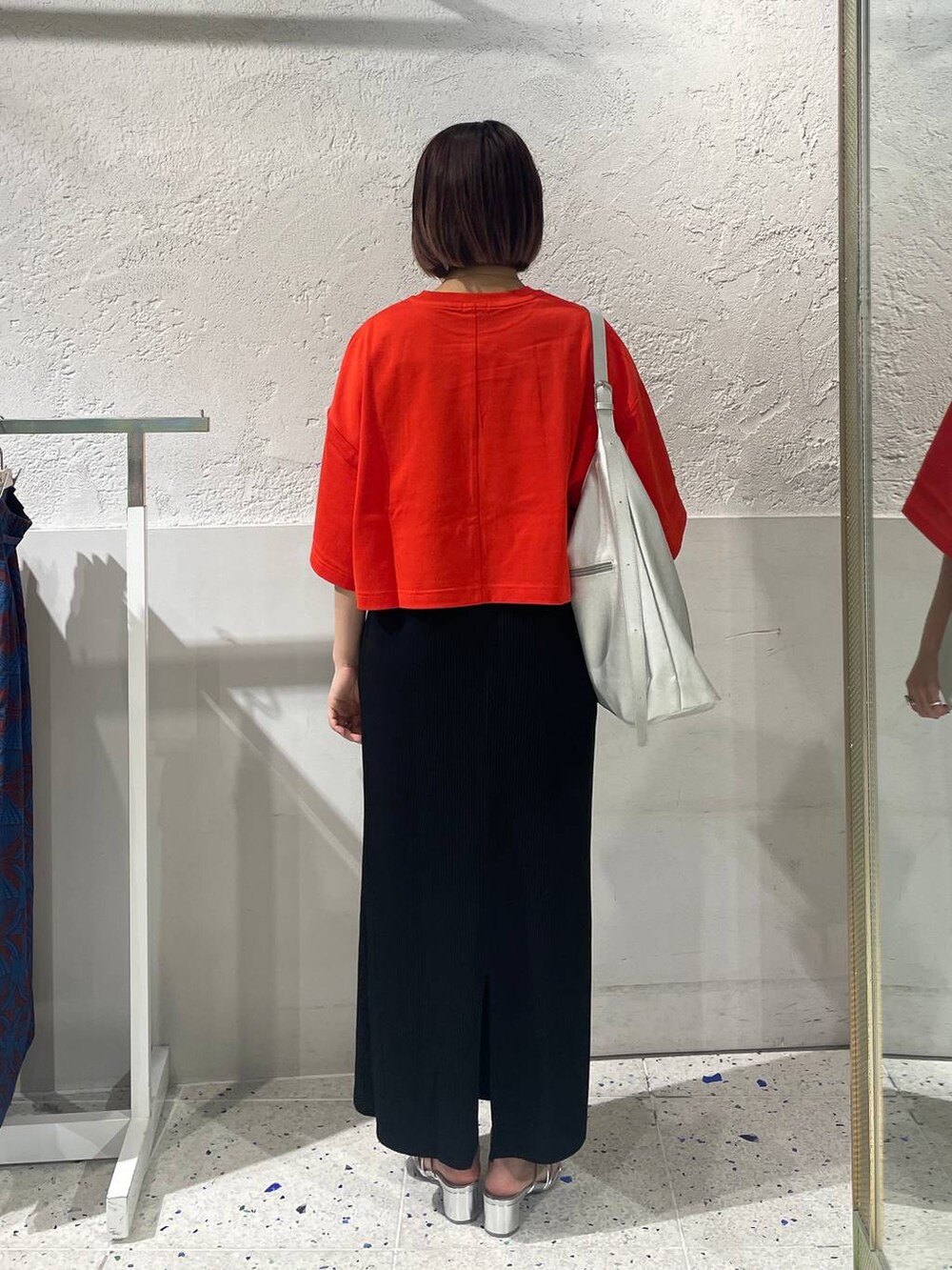 ブラック系のスカート、シルバー系のサンダル、レッド系のTシャツ/カットソーを着用したレディースの春コーディネートの3枚目の写真