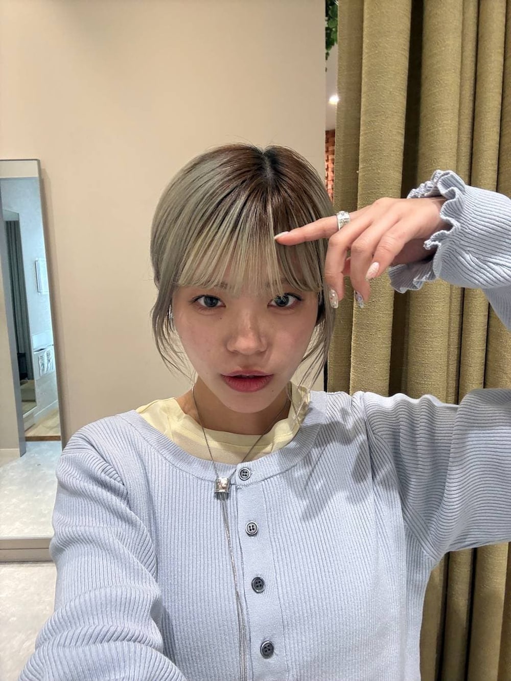 イエロー系のTシャツ/カットソー、ベージュ系のデニムパンツ、ホワイト系のブルゾンを着用したレディースの冬コーディネートの5枚目の写真