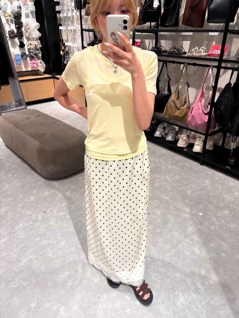 イエロー系のTシャツ/カットソー、ブラウン系のサンダル、ホワイト系のスカートを着用したレディースの夏コーディネートの2枚目の写真
