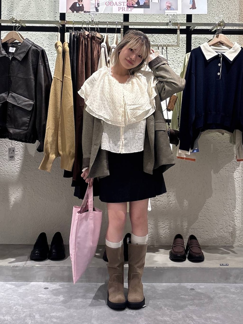 ブラウン系のテーラードジャケット、ベージュ系のブーツ、ピンク系のトートバッグを着用したレディースの春コーディネートの5枚目の写真