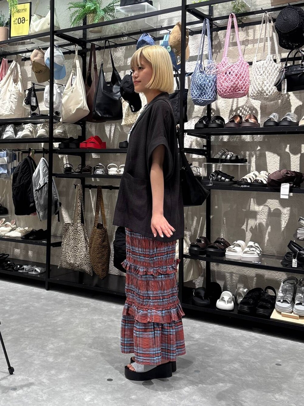 シルバー系のサンダル、ホワイト系のTシャツ/カットソー、ブラック系のショルダーバッグを着用したレディースの夏コーディネートの4枚目の写真