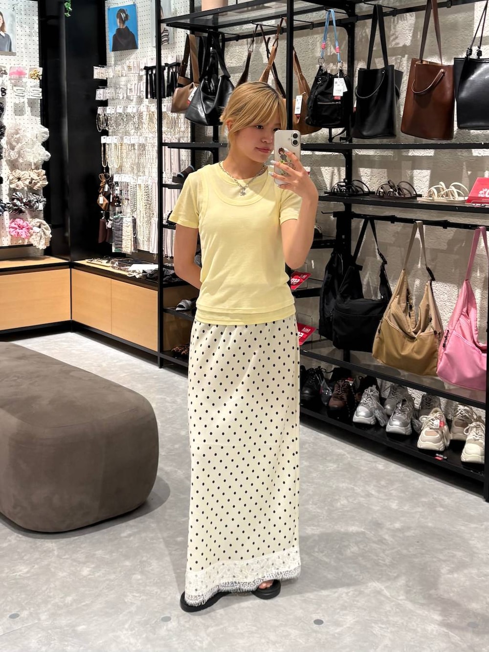 イエロー系のTシャツ/カットソー、ブラウン系のサンダル、ホワイト系のスカートを着用したレディースの夏コーディネートの3枚目の写真