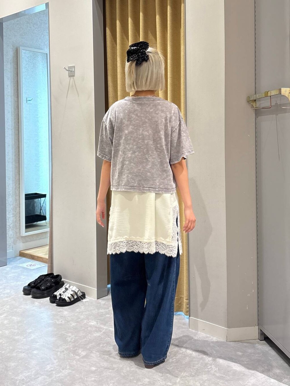 ブルー系のデニムパンツ、ブラウン系のサンダル、グレー系のTシャツ/カットソーを着用したレディースの夏コーディネートの3枚目の写真