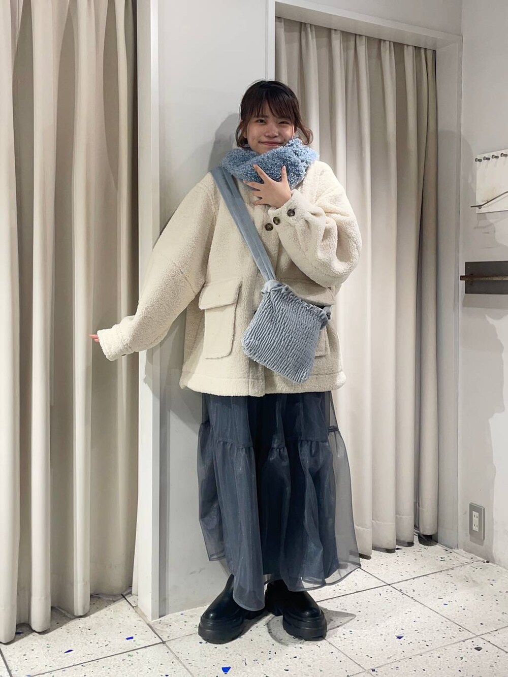 ホワイト系のTシャツ/カットソー、ブラック系のブーツ、ホワイト系のブルゾンを着用したレディースの冬コーディネートの4枚目の写真