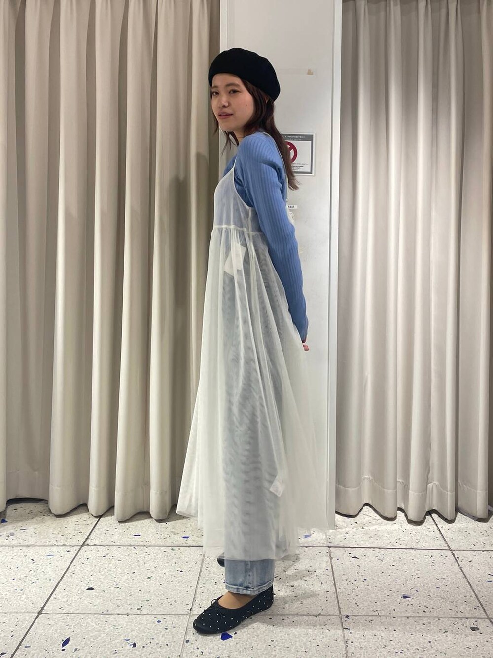 ホワイト系のワンピース、ブルー系のデニムパンツ、ブルー系のニット/セーターを着用したレディースの冬コーディネートの2枚目の写真