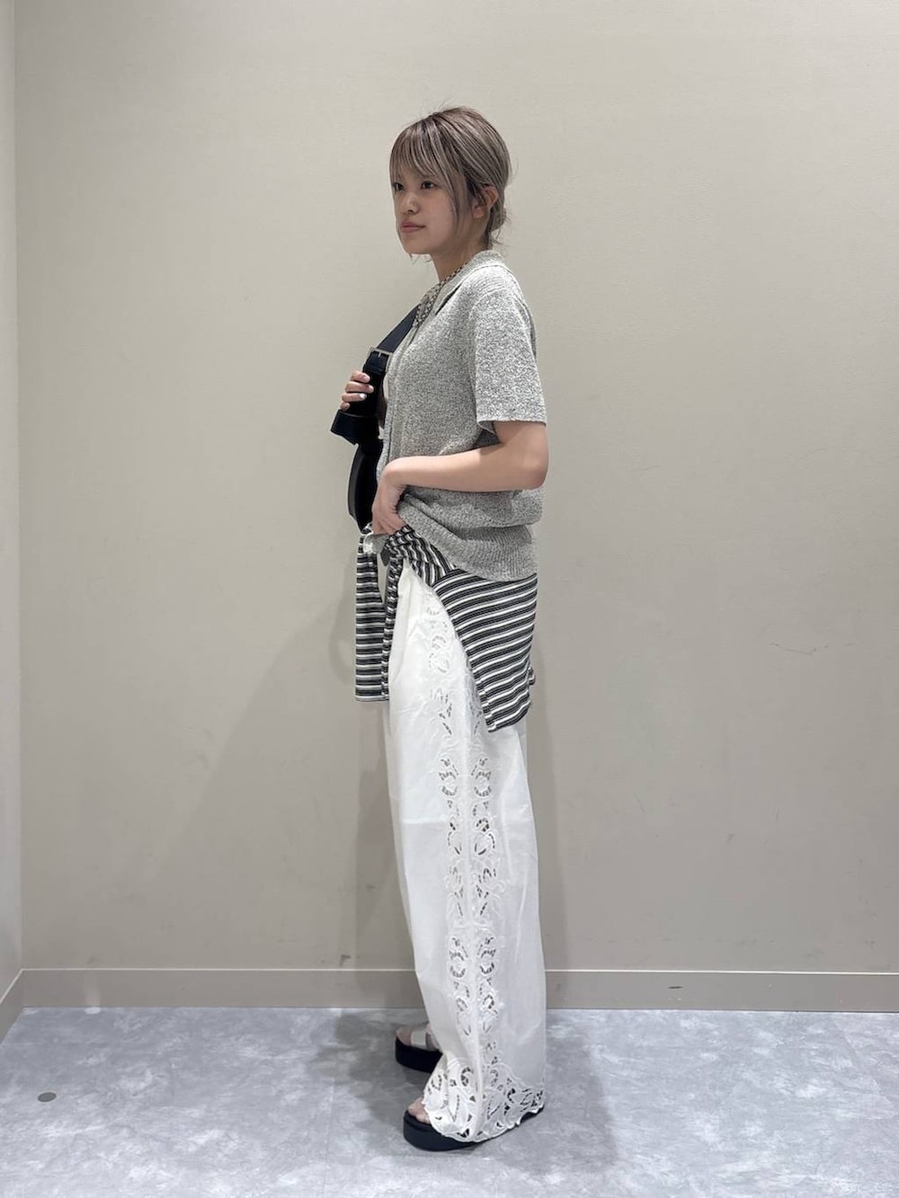 シルバー系のサンダル、ブラック系のショルダーバッグ、ホワイト系のその他パンツを着用したレディースの春コーディネートの4枚目の写真