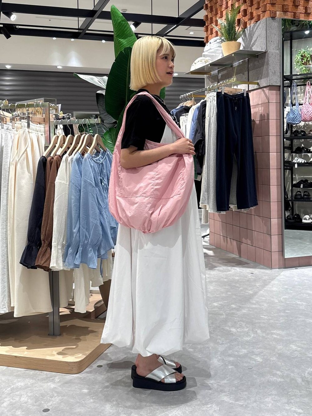 シルバー系のサンダル、ピンク系のトートバッグ、ホワイト系のワンピースを着用したレディースの夏コーディネートの2枚目の写真