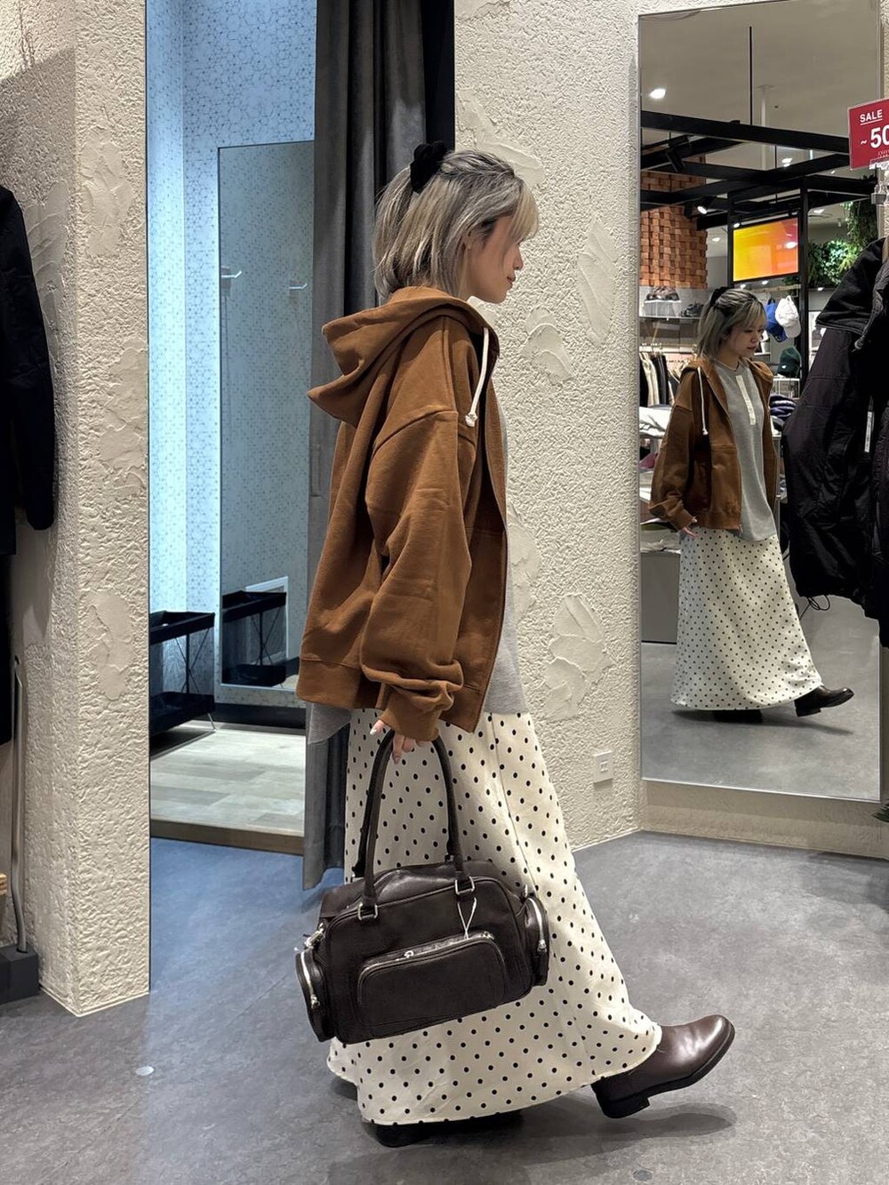 ホワイト系のスカート、ブラウン系のボストンバッグ、グレー系のTシャツ/カットソーを着用したレディースの冬コーディネートの4枚目の写真