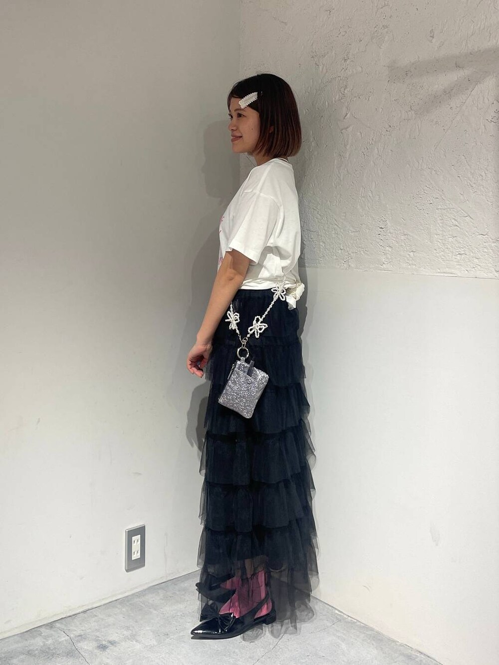 ブラック系のパンプス、ブラック系のスカート、ホワイト系のTシャツ/カットソーを着用したレディースの夏コーディネートの4枚目の写真