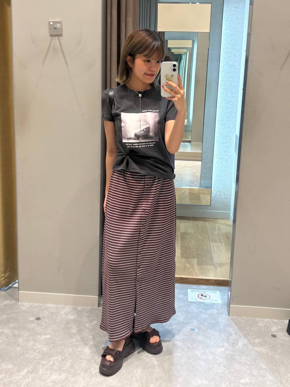 グレー系のTシャツ/カットソー、ブラック系のショルダーバッグ、ブラウン系のサンダルを着用したレディースの夏コーディネートの2枚目の写真