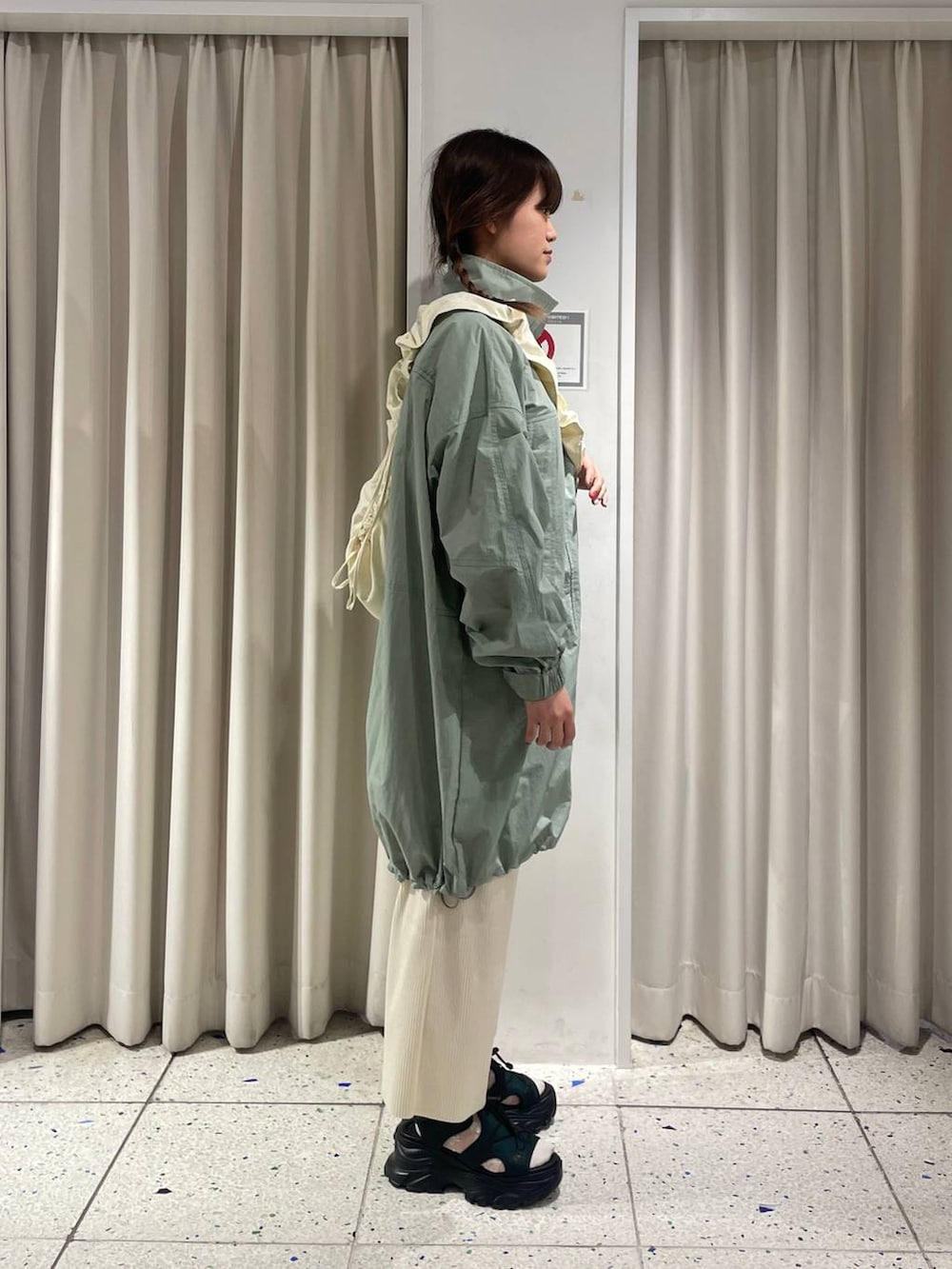 ホワイト系のスカート、グリーン系のサンダル、ホワイト系のショルダーバッグを着用したレディースの春コーディネートの2枚目の写真