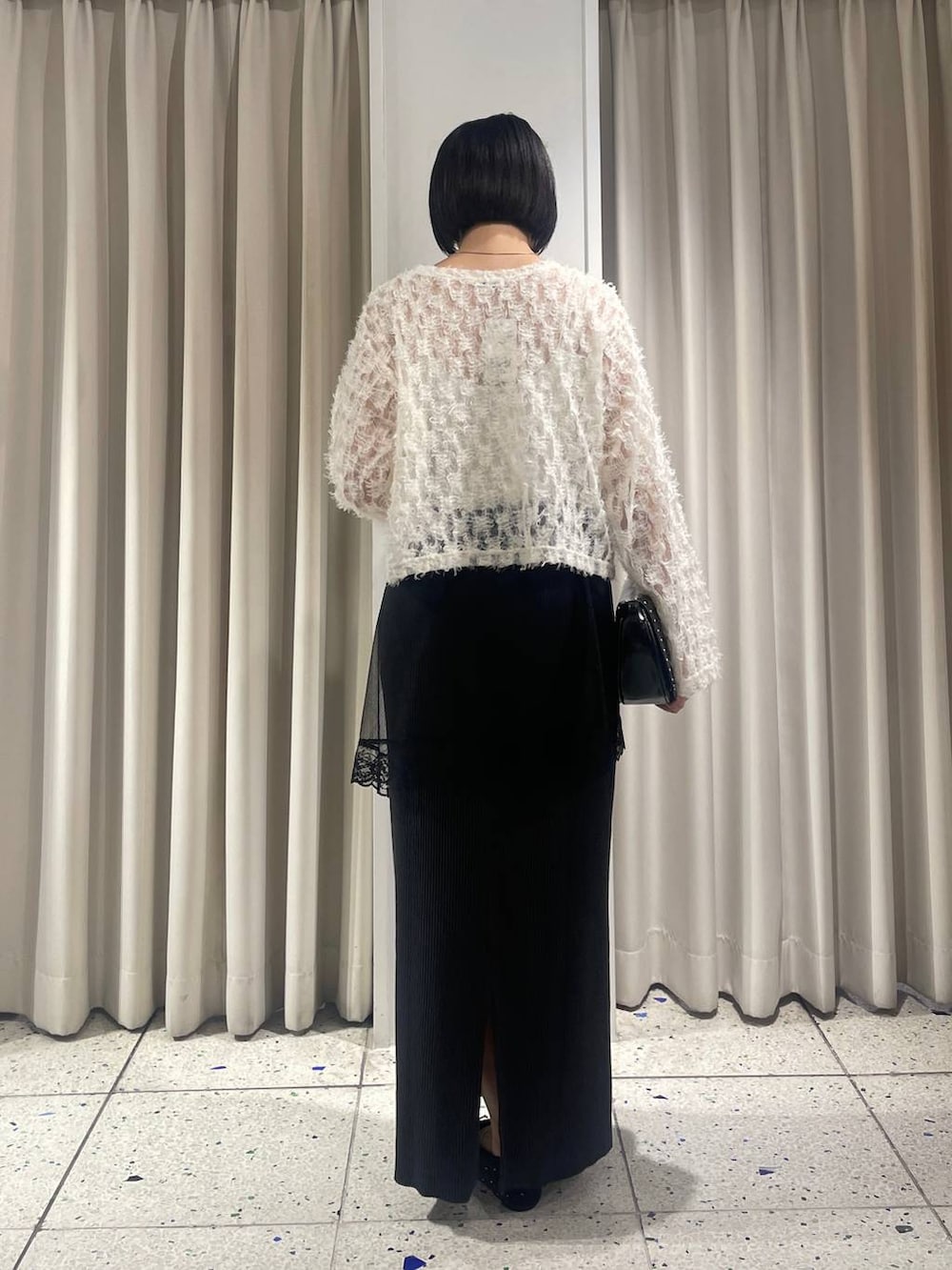 ブラック系のスカート、ブラック系のバレエシューズ、ブラック系のショルダーバッグを着用したレディースの秋コーディネートの3枚目の写真